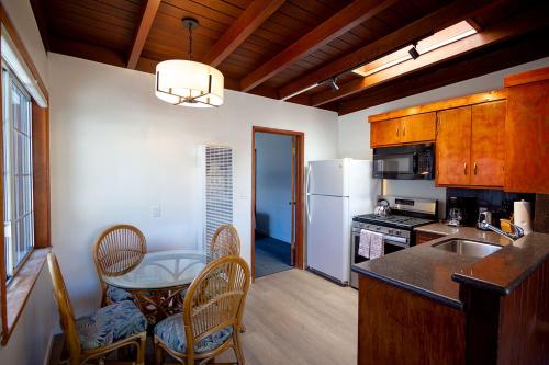 a kitchen with a table and chairs and a refrigerator at Edgewater Beach Inn in Santa Cruz