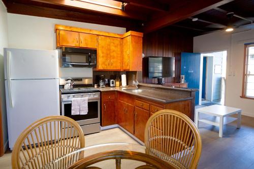 a kitchen with a white refrigerator and wooden cabinets at Edgewater Beach Inn in Santa Cruz