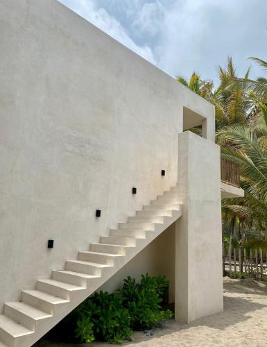a concrete staircase on the side of a building with palm trees at Cocuna Boutique Suites La Manzanilla Jalisco in La Manzanilla