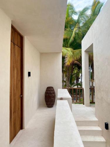 a hallway of a house with stairs and a wooden door at Cocuna Boutique Suites La Manzanilla Jalisco in La Manzanilla