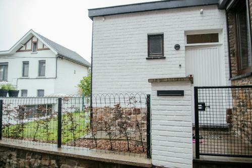 a white house with a fence in front of it at La Courte Échelle in Verviers