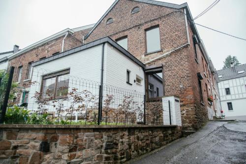a brick building with a fence on the side of it at La Courte Échelle in Verviers