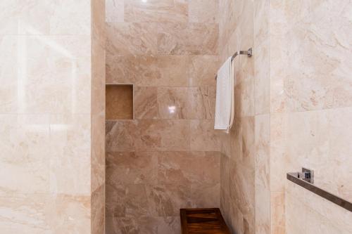 a bathroom with a shower with a stone wall at The Link Hotel South Beach in Miami Beach