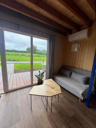 a room with a bed and a table and a large window at Morska 2K in Łukęcin