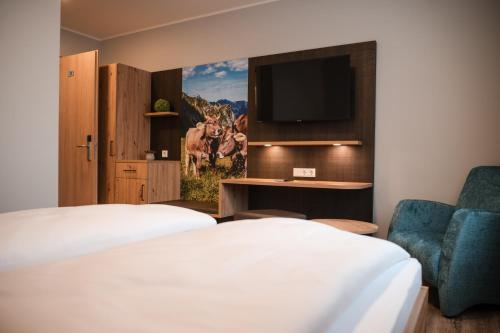 a hotel room with two beds and a tv at Gasthaus Stroh in Buchholz