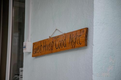 a wooden sign hanging on a wall at Hotel Good Night in Jalal-Abad