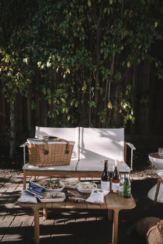a picnic table with food and two bottles of wine at Brannan Cottage Inn in Calistoga