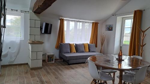 un salon avec une table et un canapé dans l'établissement Au Cœur des vignes, à Mareuil-sur-Cher