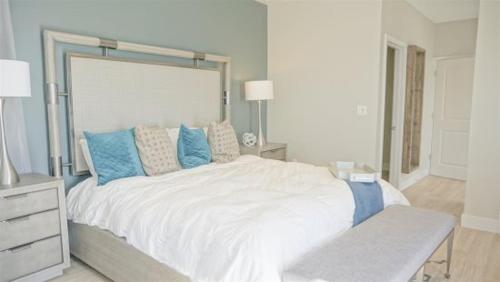 a bedroom with a large white bed with blue pillows at Endless Summer 42 in Key Largo