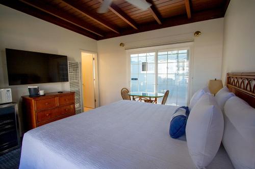 a bedroom with a bed with a television and a table at Edgewater Beach Inn in Santa Cruz
