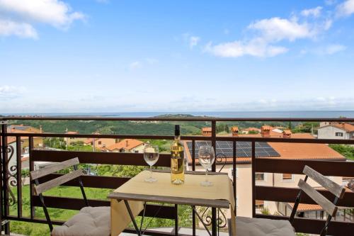 a table with two glasses of wine on a balcony at Hiša Ivančič in Šared