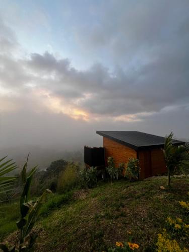 a house on top of a hill in the mist at Entre Nubes Eco Hotel in El Queremal