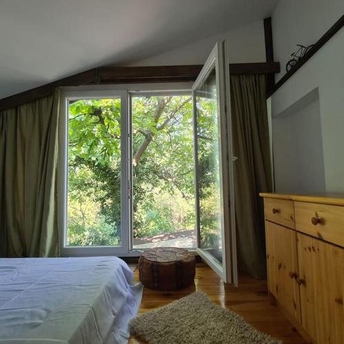 a bedroom with a bed and a large window at Mansarda boema, gradina de basm in Bucharest
