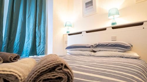 a bedroom with a bed with blue curtains at Pebbles guest house room 11 in Southampton