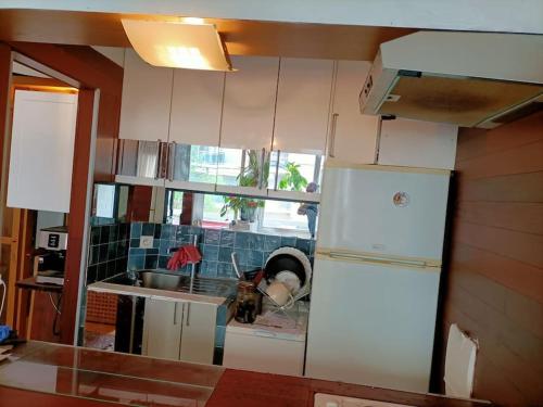 une cuisine avec des armoires blanches et un réfrigérateur blanc dans l'établissement Green Paris 1, à Neuilly-sur-Seine