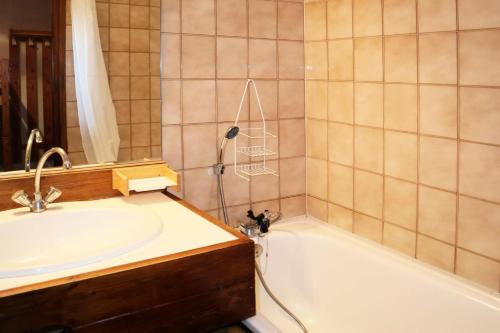 une salle de bain avec un lavabo, une baignoire et un miroir dans l'établissement Résidence Le Cairn - 1010 CAIRN LES ORRES 1650 MAE-0934, aux Orres