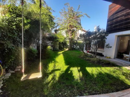 - un jardin avec une balançoire dans la cour dans l'établissement Maison avec jardin à proximité du centre ville et des plages, Montpellier, à Montpellier