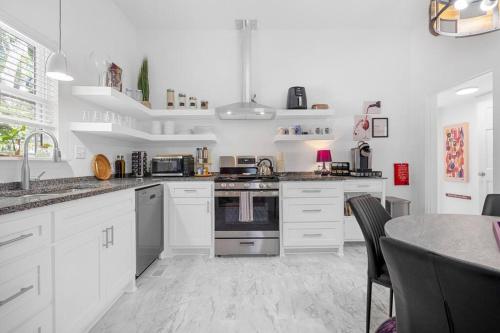 a kitchen with white cabinets and a stove top oven at Vineyard Cottage-Pet Friendly & Walk to Oaklawn! in Hot Springs