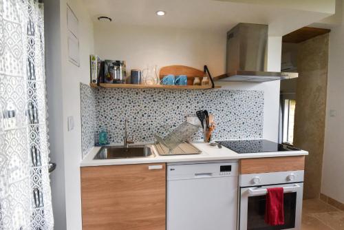 a small kitchen with a sink and a stove at Cabane Tourangelle - La petite Bohème in Rigny-Ussé