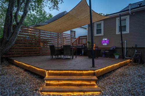 a wooden deck with a table and chairs on it at Vineyard Cottage-Pet Friendly & Walk to Oaklawn! in Hot Springs