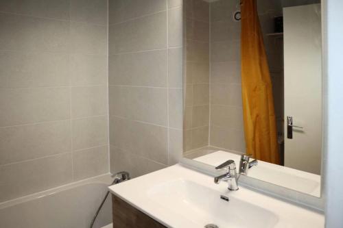 une salle de bain avec un lavabo, une baignoire et un miroir dans l'établissement Résidence Les Carlines - Résidence LES CARLINES studio équipé pour 4 personnes MAE-2274, à Le Mélézet