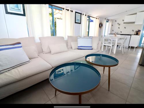 - un salon avec un canapé blanc et 2 tables dans l'établissement Maison à la plage, à Canet