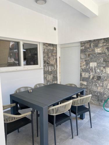 a black table and chairs in a room with a stone wall at Anafis Exclusive in Athens