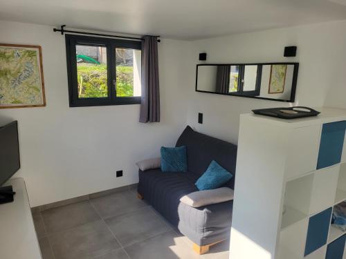 un salon avec un canapé et une fenêtre dans l'établissement Studio Saint Antoine Les Houches, aux Houches