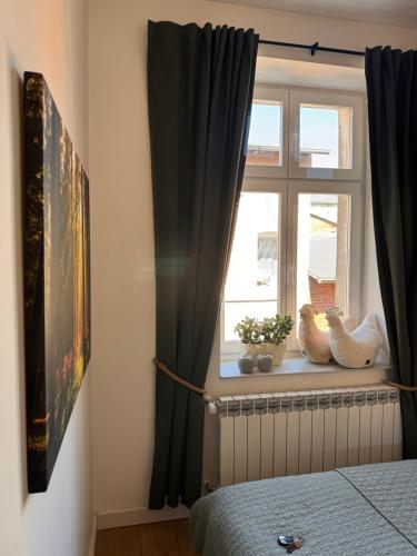 a bedroom with a window with black curtains at Apartament Tuchola in Tuchola