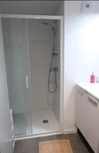 une salle de bain avec une douche avec une porte vitrée dans l'établissement Variations, à Saint-Herblain
