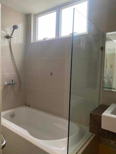 a bathroom with a bath tub and a sink at Mactan Newtown Beach Condo in Mactan