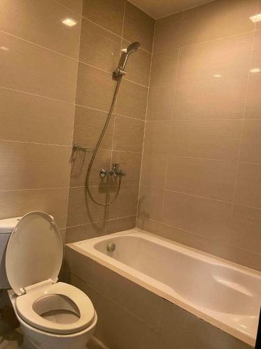 a bathroom with a toilet and a bath tub with a shower at Mactan Newtown Beach Condo in Mactan