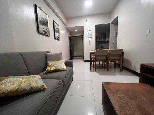 a living room with a couch and a dining room at Mactan Newtown Beach Condo in Mactan