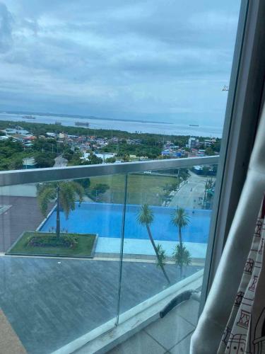 a view of a swimming pool from a window at Mactan Newtown Beach Condo in Mactan