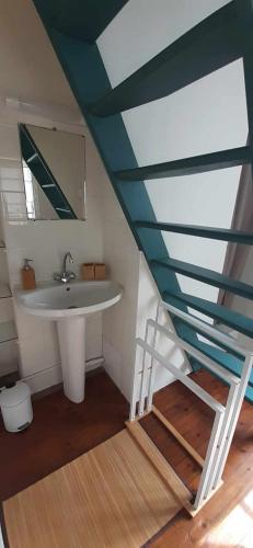 une salle de bain avec un lavabo et un miroir dans l'établissement L'Escapade Tréportaise, au Tréport