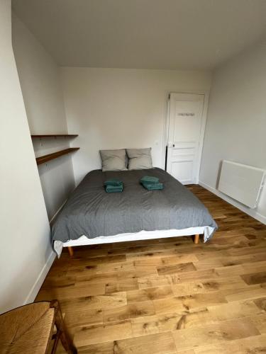 une chambre avec un lit et un parquet dans l'établissement Chez Luna - Stade de France - Paris, à Saint-Denis