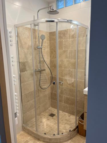 une douche avec une cabine en verre dans une salle de bain dans l'établissement Chez Luna - Stade de France - Paris, à Saint-Denis