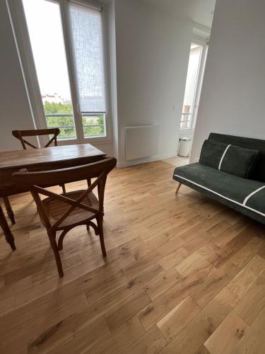 un salon avec une table et un canapé dans l'établissement Chez Luna - Stade de France - Paris, à Saint-Denis