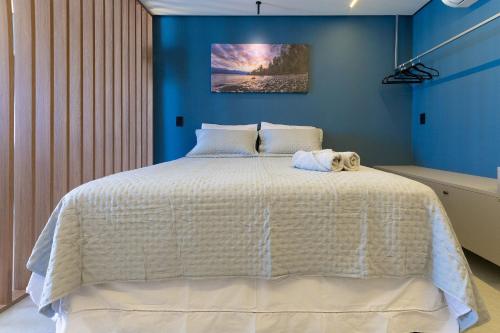 a bedroom with a white bed with a stuffed animal on it at Urban #802 - Quádruplo espaçoso por Carpediem in Tambaú