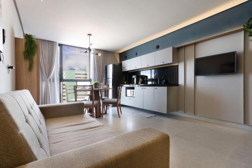 a living room with a couch and a kitchen at Urban #802 - Quádruplo espaçoso por Carpediem in Tambaú