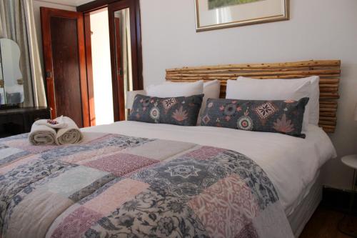 a bedroom with a large bed with pillows at CasaMia in Bredasdorp