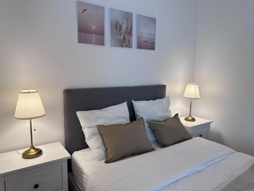 - une chambre avec un lit blanc et 2 lampes dans l'établissement Appartement Cosy proche PARIS, à Aulnay-sous-Bois