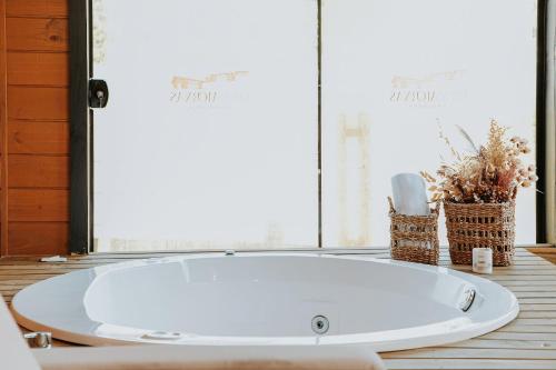 baño con bañera blanca y ventana en Cabana do Lago - Villas Mornas Natureza e Jacuzzi, en Aguas Mornas