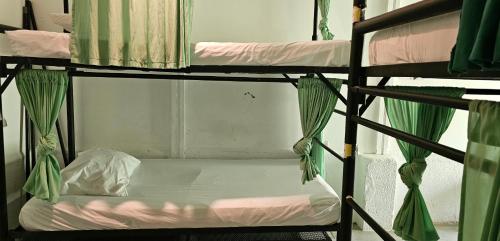 a couple of bunk beds with a white bed at Casa Oro Eco Hostel in San Juan del Sur