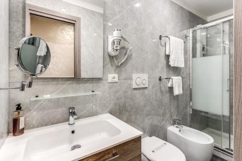 a bathroom with a sink and a toilet and a mirror at Hotel Centro Cavour Roma in Rome