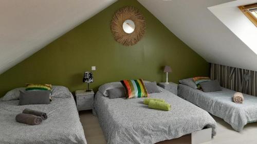 two beds in a room with a green wall at Home Sweet Home in Le Mans