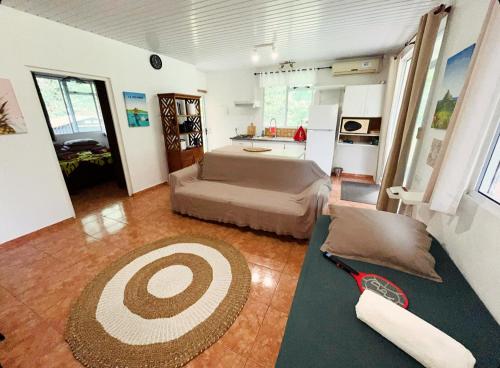a living room with a bed and a kitchen at FARE ARIKI MOOREA in Afareaitu