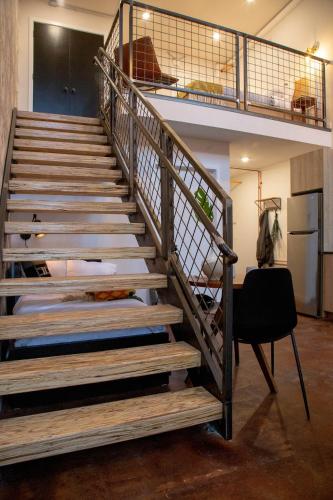 a wooden staircase in a room with a chair at Viaduct Loft at Kestrel Hotel in Philadelphia