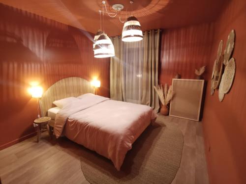 - une chambre avec un lit, deux lumières et une table dans l'établissement Le cocon de Bondy, à Bondy