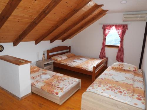 a bedroom with three beds and a window at Etno selo ŽURIĆ in Mojkovac